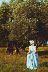 Young elegant happy lady  in vintage clothes dress walking in the nature at her summer vacation