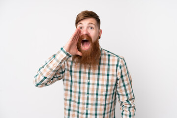 Redhead man with long beard over isolated white background shouting with mouth wide open