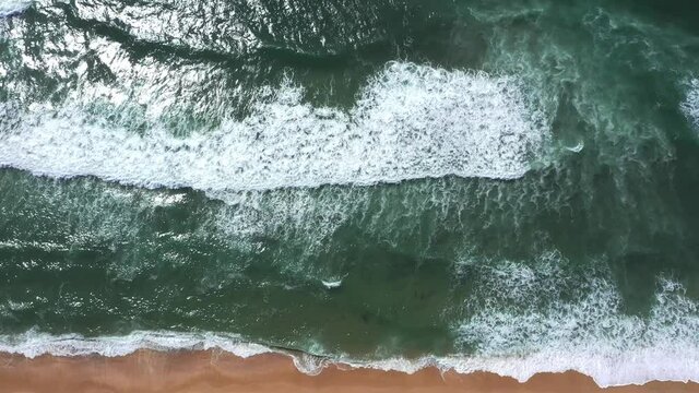 Aerial View Of Waves Crashing On Beach. jib down