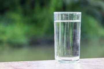 A glass of fresh drinking water on a green background