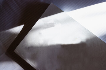 White book on the table. Play of light and shadow.