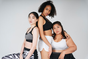 Fototapeta na wymiar Three diverse women with asian and african in sport bra outfit on white background.