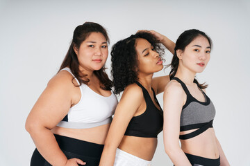 Portrait of diverse with asian and african women in wear sport bra outfit on white background.