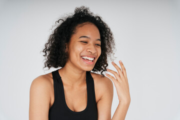 Cheerful and laugh african woman in black sport bra on white background.