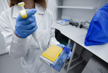Laboratory assistant working with dispenser in laboratory