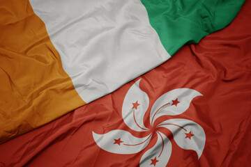 waving colorful flag of hong kong and national flag of cote divoire.