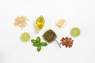 Pesto sauce. Pine nut. Parmesan on paper. Pesto in bowl, basil leaves, garlic and lemon.