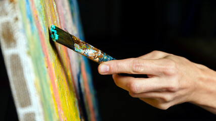 Close-up view of highly gifted painter while he is painting his picture.