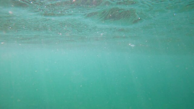 Waves underwater with bubbles and sun rays. Ocean water textures