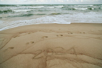 Fototapeta na wymiar 2021 inscription written on the sand, New Year is coming concept