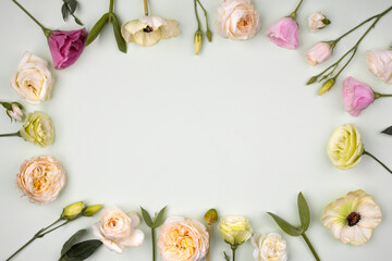 Creative frame made with flowers on pastel background. Spring minimal concept. Flat lay.