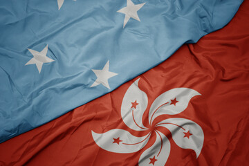 waving colorful flag of hong kong and national flag of Federated States of Micronesia .