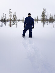 Hombre con mono de nieve de espaldas sobre la nieve de Laponia