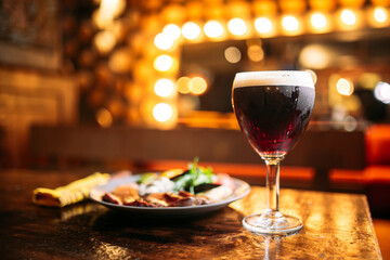 Meat and vegetables dish with a glass of dark beer