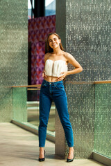 Full body portrait of a young brunette woman in blue jeans