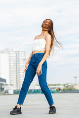 Full body portrait of a young woman in blue jeans