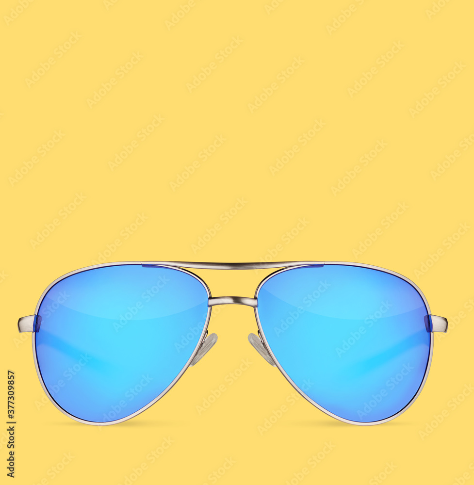 Wall mural Sunglasses with blue lens over yellow background