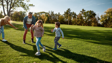Obraz premium Happy childhood memories. Excited family running outdoors on a sunny day