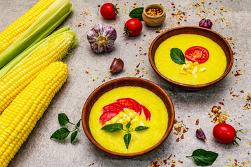 Corn cream soup with fresh vegetables, herbs and spices