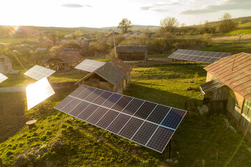 Aerial top down view of solar panels in green rural village yard.
