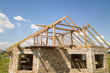 Obraz premium Aerial view of unfinished house with wooden roof frame structure under construction.