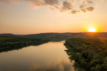 Aerial view of sunset over wide Dnister river and distant rocky hills in Bakota area, part of the National park 