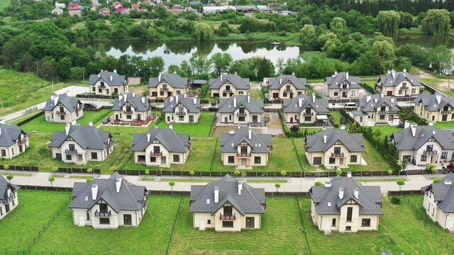 Sweeping Aerial Shoot Of Residential Area With Modern Mansions In Countryside. Flying Drone Point Of View Of Riverside Area With Private Houses. Real Estate, Neighbourhood.