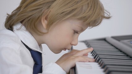 Portrait of elegant blond little child play piano, innocent passion for music