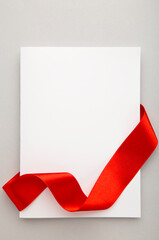 Close up of a note card with ribbon bow on grey background