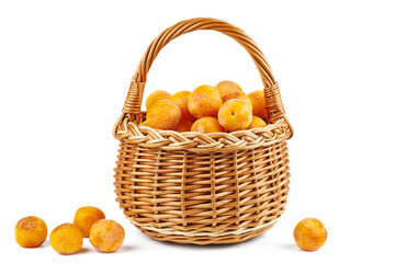 Wicker basket with half-dried yellow cherry plums isolated on the white background