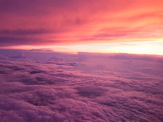 Stunning purple red sky and clouds during sunset, view from the plane