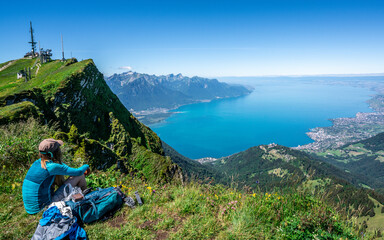 Unrecognizable tourist hiker admiring the aerial view of Lake Geneva from Rochers-de-Naye mountain...