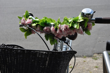 Fahrrad, ein Fahrradlenker mit Blumendekoration und Fahrradkorb, symbolisch für Radfahren und Umweltschutz