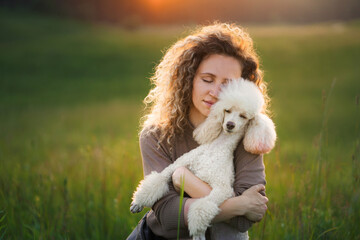 woman and two dogs on a field at sunset.