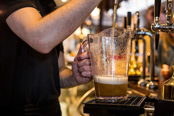 Fototapeta na wymiar Bartender pouring beer on a pub background.