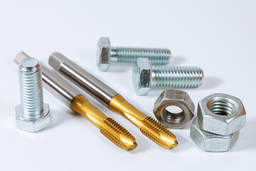 Set of tap for threading in metal. Bolts and nuts isolated on white background. Tool for metal processing.