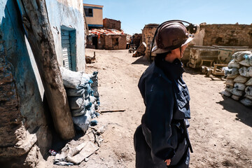 Mining woman with safety helmet at mine exit in mining town