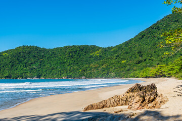 Brazilian landscape of mountain covered by a green carpet of tropical jungle, next to beautiful beach