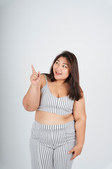 Healthy asian chubby woman pointing at product on white background.