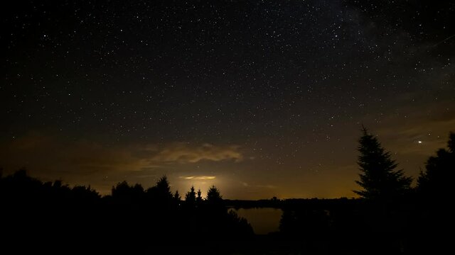 Night Sky Time Lapse. Night sky over lake and trees.