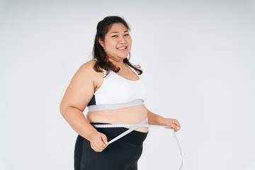 Healthy asian chubby woman in white sportbra and measuring tape.