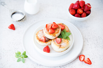 Curd cheesecakes with strawberries and powdered sugar, dessert