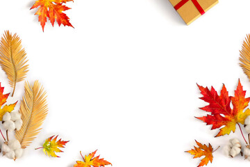 Autumnal frame of maple leaves, golden yellow leaves palm tree, cotton flowers, gift box on white background with space for text. Top view, flat lay