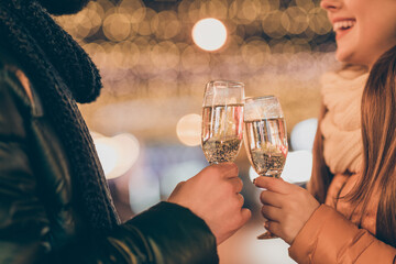Cropped photo of couple celebrate x-mas christmas newyear clink cheers champagne glass outdoors wear season clothes