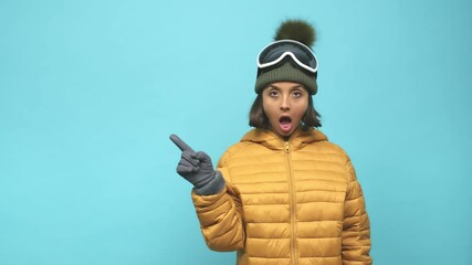 Young snowboard indian woman pointing to the side