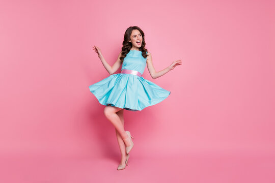 Full length photo of attractive curly lady glamorous clothes event night club dancing skirt flying wear blue teal dress high-heels isolated pastel pink color background