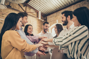 Photo of handsome business men pretty ladies people partners spacious big office seven members best friends hold arms celebrate successful project investment teammates professionals indoors