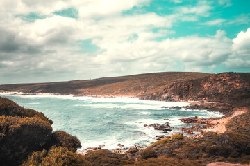 Deserted beach, rocky bay with waves and blue and turquoise water, Western Australia