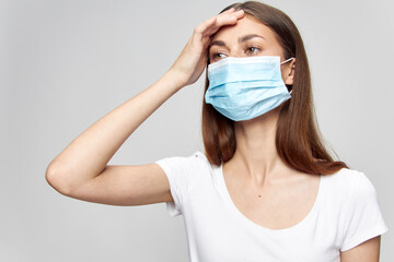  girl in a medical mask touches her head with her hand health problems high fever for a duel