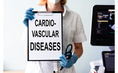 Cardiovascular Diseases - text on the board in the doctor hands. The female doctor in the white...